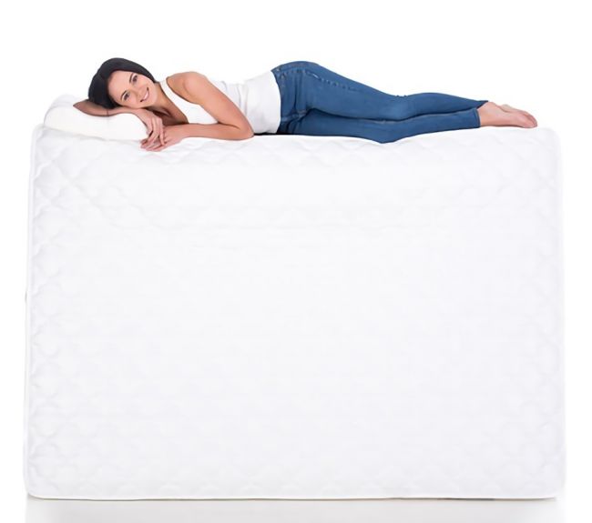 厚いマットレスに寝る女性の画像