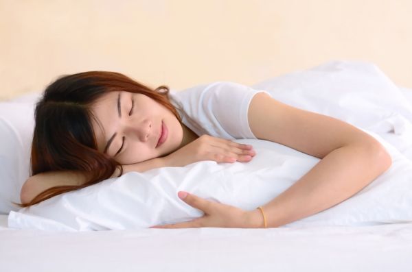 大きめの枕で眠る女性の画像